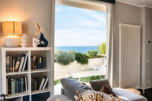 a living room with a book shelf with a view of the ocean at Suite Apartments Rimini - Seafront in Rimini