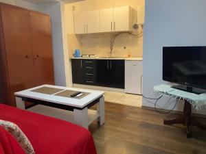 a living room with a table and a kitchen at Balkan House in Mostar