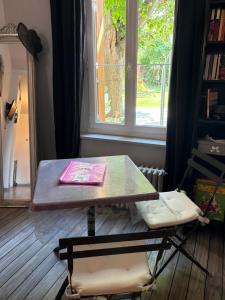 a table and a chair in a room with a window at La Cathare in Lézignan-Corbières