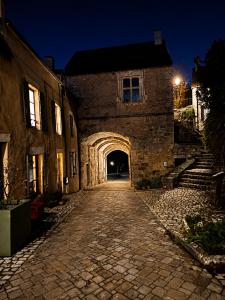 an old stone building with an archway at night at Au Morvan Voyageur in Asquins +7 photos