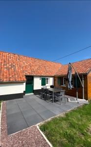 a patio with a table and chairs in front of a house at Cottage de la Maye in Rue