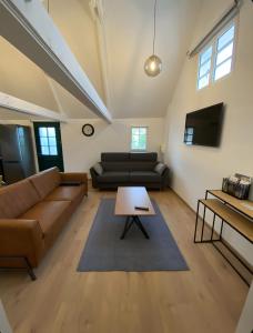 a living room with a couch and a table at Cottage de la Maye in Rue