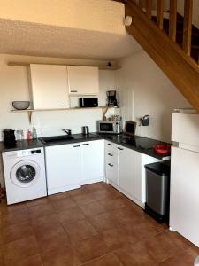 a kitchen with white cabinets and a washer at Corse Appartement Sognu di Mar Marine de Bravonne à Linguizzetta in Linguizzetta