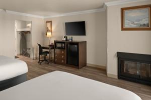 a hotel room with a bed and a fireplace at Cannery Row Inn in Monterey