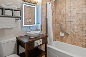 a bathroom with a sink and a toilet and a tub at Cannery Row Inn in Monterey +41 photos