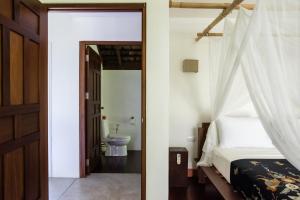 阁遥岛Koyao Bay Pavilions - Beach Resort and Pool Villas的一间卧室配有一张床,浴室设有卫生间