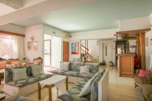 a living room with blue couches and a table at Violetta Hotel in Amoudara Herakliou
