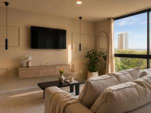a living room with a couch and a tv at DreamHaus Suites - Country Club Guadalajara in Guadalajara