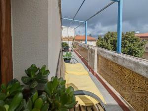 a balcony with a yellow table and chairs on it at Nautilus in Cuglieri
