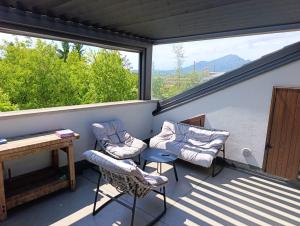 a screened in porch with two chairs and a table at Mansarda Boutique May in Bergamo