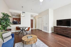 a living room with a couch and a table at Suite Bleu 5 Min walk to Bourbon st Rooftop Pool in New Orleans
