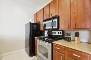 a kitchen with a stove and a microwave at Suite Bleu 5 Min walk to Bourbon st Rooftop Pool in New Orleans