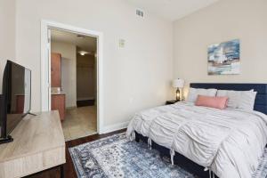 a bedroom with a bed and a flat screen tv at Suite Bleu 5 Min walk to Bourbon st Rooftop Pool in New Orleans