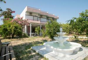 a large white fountain in front of a house at Violetta Hotel in Amoudara Herakliou