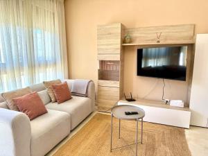 a living room with a couch and a flat screen tv at Apartmento Las Palmeras in Noalla