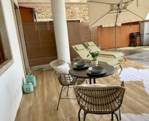 a patio with a table and chairs and an umbrella at Apartmento Las Palmeras in Noalla
