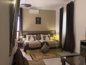 a bedroom with a bed with pillows on it at Hotel tafoukt in Marrakesh