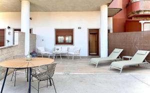 a patio with chairs and a table and chairs at Apartmento Las Palmeras in Noalla