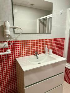 a bathroom with a sink and a mirror at Apartmento Las Palmeras in Noalla +11 photos