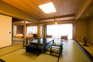 a room with a table and chairs and a bedroom at Shiragiku in Beppu