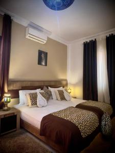 a bedroom with a bed with cheetah pillows at Hotel tafoukt in Marrakesh