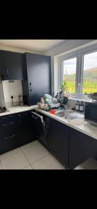 a kitchen with a counter and a sink and a window at edinburgh holiday home in Roslin