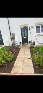 a front door of a house with flowers in front at edinburgh holiday home in Roslin +5 photos