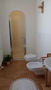 a bathroom with a toilet and two sinks and a shower at B&B Il Nocciolino in La Fabbrica