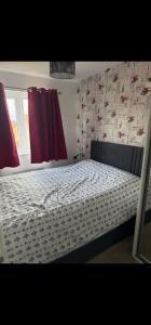 a bed in a bedroom with red curtains at edinburgh holiday home in Roslin