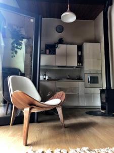 a chair in a living room with a kitchen at Forest Lounge in Petit Mesnil