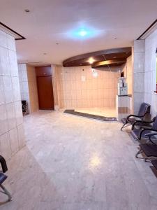 an empty room with chairs and a room with a stage at شقق مفروشة العزيزية in Hail