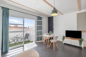 a living room with a table and chairs and a television at Suite Junior Amanecer in Mácher