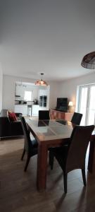 a living room with a wooden table and chairs at Le Point Relais in Fumay