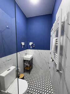 a blue bathroom with a toilet and a sink at Polifonia Inn Borjomi in Borjomi +85 photos