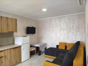 a living room with a couch and a kitchen at Apartments Svetlana in Utjeha