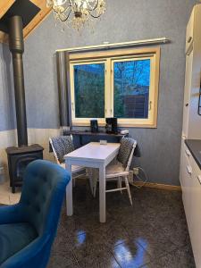 a dining room with a table and chairs and a stove at Boende nära sjö i Gyltige Simlångsdalen in Simlångsdalen