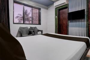 a bedroom with a bed and a tv and a window at Hotel O Jayesh Inn in Kolshet