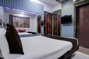a hotel room with a bed and a tv at Hotel O Jayesh Inn in Kolshet