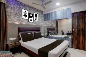 a bedroom with two beds and a brick wall at Hotel O Jayesh Inn in Kolshet +21 photos