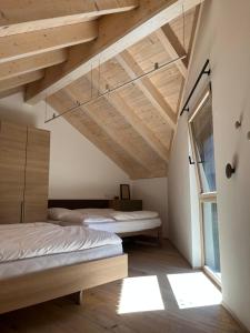 two beds in a room with wooden ceilings at The Mountain Nest in Russbach am Pass Gschütt