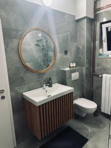 a bathroom with a sink and a toilet and a mirror at House Burić in Otočac +18 photos