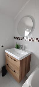 a white bathroom with a sink and a mirror at Le Point Relais in Fumay +13 photos