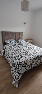 a bedroom with a bed with a black and white comforter at Le Point Relais in Fumay