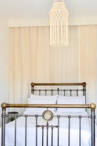 a bed in a bedroom with a chandelier at Demetra Waterfront House-Authentic Syros, by Elefthia Syros in Megas Gialos - Nites