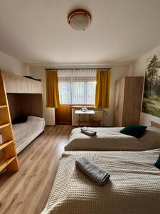 a bedroom with two beds and a window at Dunajecki Zakątek z Jacuzzi in Biały Dunajec