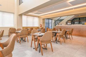 a restaurant with tables and chairs in a room at Aruba Casablanca City Center in Casablanca