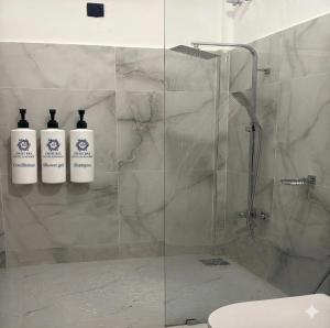 two bottles ofodorizers sit on a glass shower stall at Swiss Bay Hotel & Resort-Arugambay in Pottuvil +31 photos