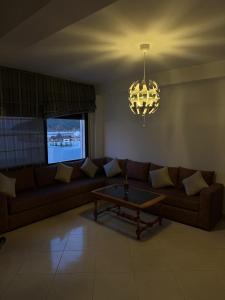 a living room with a couch and a chandelier at Étoile in M'diq