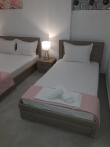 two beds in a room with a lamp on a table at VILLA stamatia - lena in Limenaria