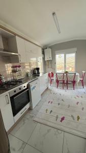a kitchen with a table and chairs and a rug at Peribacası Manzaralı Modern Daire 2 in Ürgüp